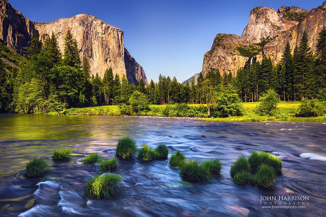 Summer view of Yosemite Valley with El Capitan and Cathedral Rocks framing the Merced River in Yosemite National Park, California