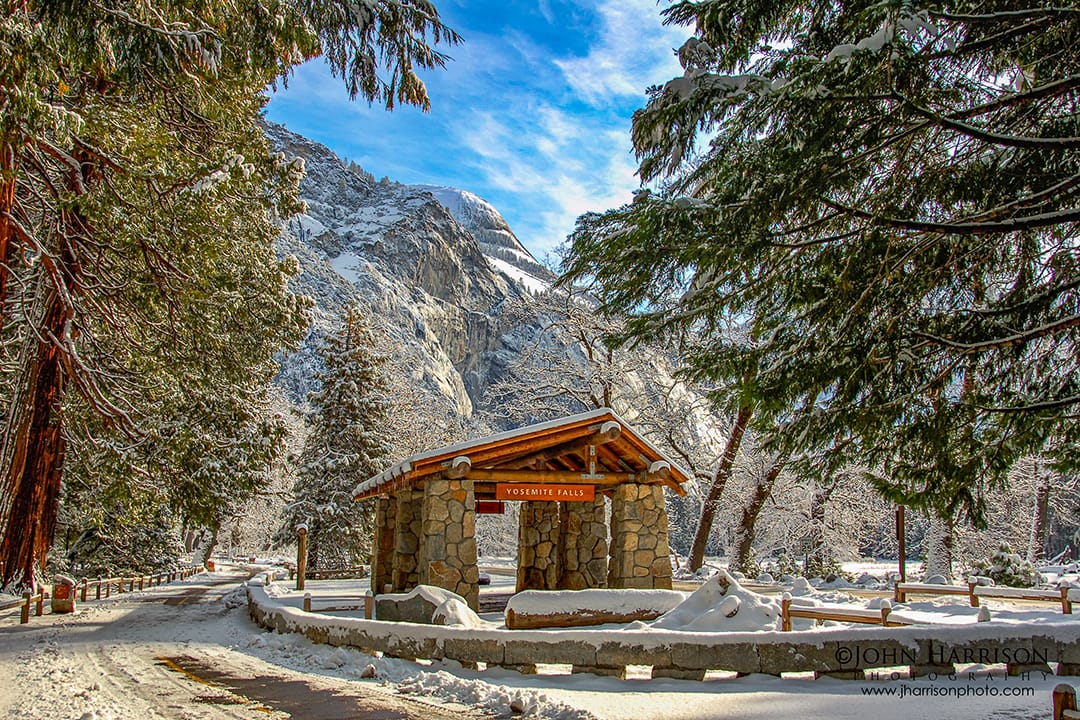 Fresh snowfall covering Yosemite Falls bus stop and Cook’s Meadow on a bright winter morning in Yosemite Valley, with snow-dusted pine trees and granite cliffs in Yosemite National Park