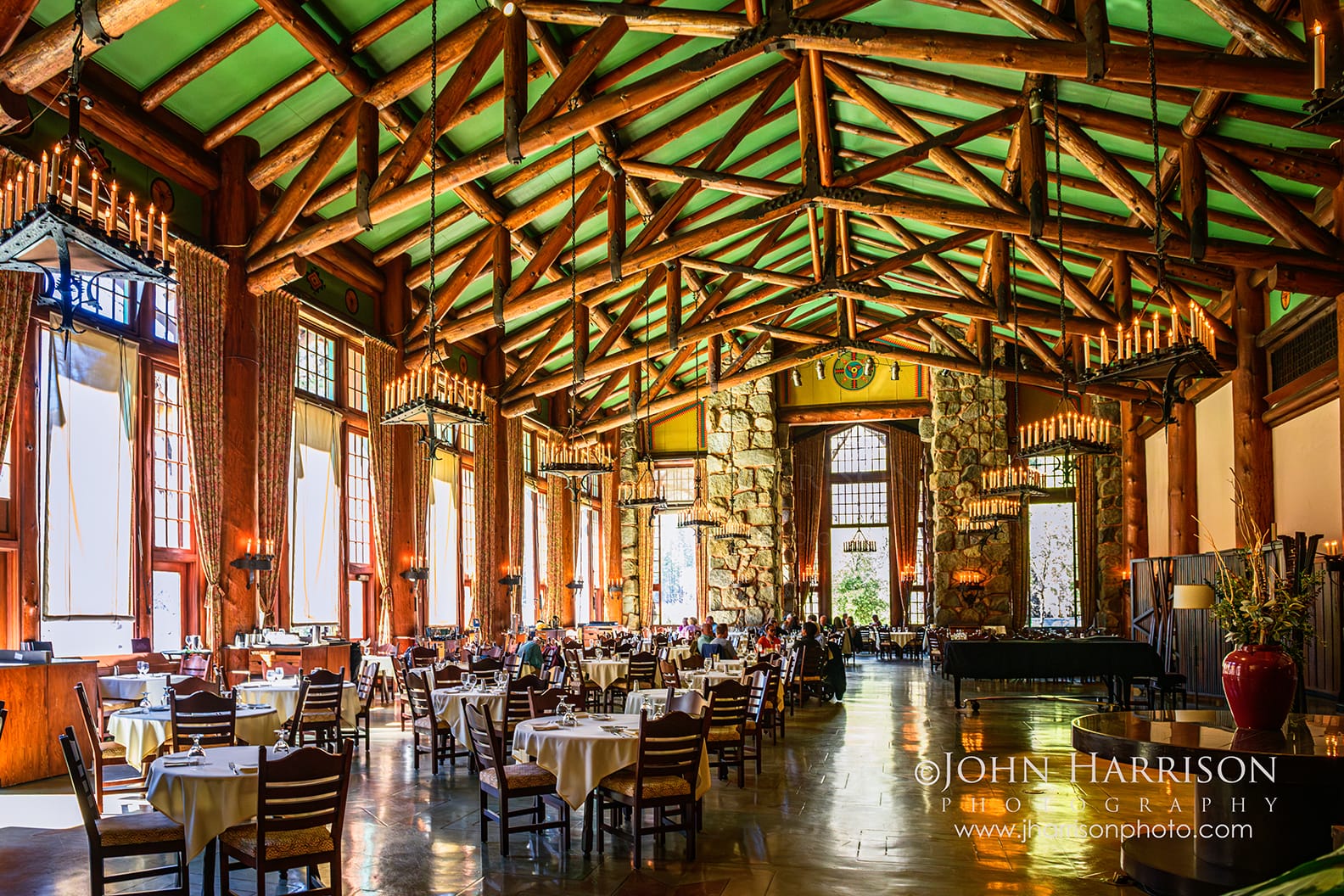 The Grand Dining Room inside The Ahwahnee hotel in Yosemite National Park with massive timber beams, chandeliers, and tall windows overlooking Yosemite Valley.
