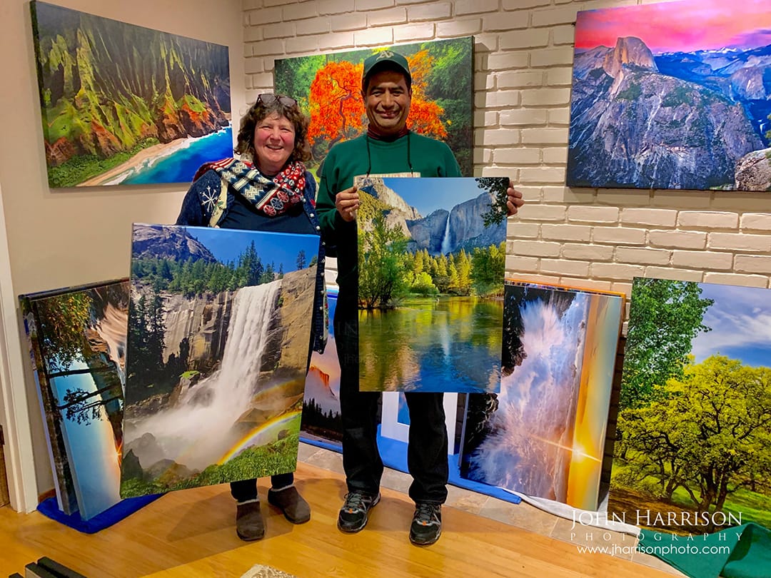 Captured here are two delighted collectors welcoming museum-quality waterfall photography from Yosemite National Park into their home—fine art pieces created by a dedicated Yosemite landscape specialist known for photographing the park across seasons, light, and water flow conditions.  “Reflections of Yosemite Falls in the Merced” is a 20” x 30” gallery-wrapped giclée canvas, personally produced in my home printing studio to ensure accurate color, detail, and archival quality. This spring scene captures Yosemite Falls mirrored in the still Merced River—an image prized by Yosemite travelers, nature lovers, and collectors seeking a calm, restorative focal point for offices, bedrooms, and professional spaces.